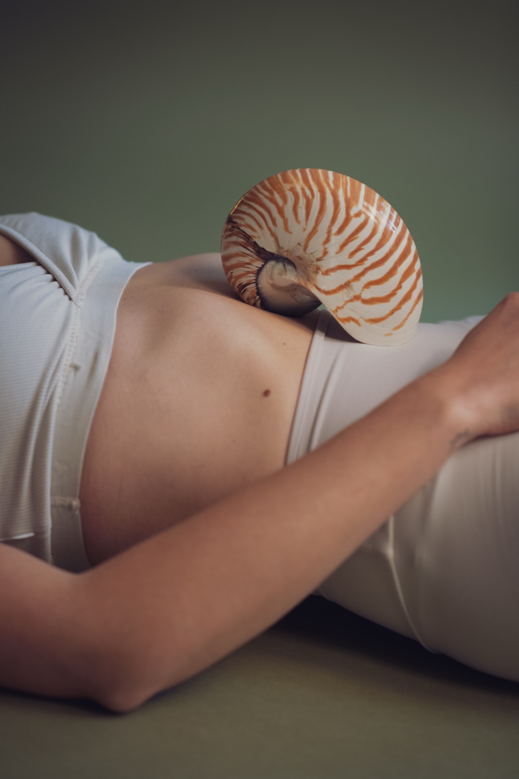 Caroline Pupp, liegend, mit einer Nautilus-Muschel